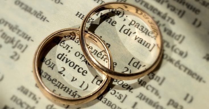 alianzas de matrimonio sobre un libro simbolizando un divorcio